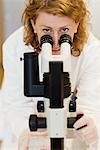 A female researcher with a microscope.