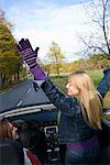 Two young women driving a cabriolet an autumn day, Sweden.