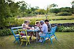 Une famille multigénérationnelle manger dans le jardin, Suède.