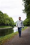 Ein Mann zu Fuß neben einem Kanal, Schweden.