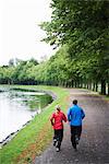 A couple jogging alongside a canal, Sweden.