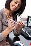 A woman doing her nails at the office.