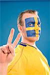 A man with the Swedish flag painted in his face.