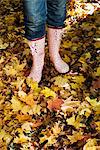 A woman wearing rubber boats in autumn forest, Stockholm, Sweden.