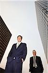 Businessman Standing near Skyscrapers