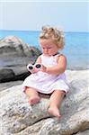 Little Girl with Sunglasses Sitting on Rock