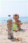 Fille jouant avec des mégots de cigarettes sur la plage