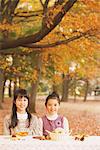 Girls Having Food In Park In Autumn