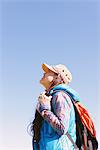 Jeune femme souriante et regardant vers le haut dans le ciel