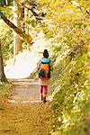 Young Woman Walking Alone On Path Through Forest