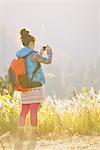 Young Woman Taking Photograph Of Nature Scene