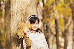 Girl In Autumn Foliage Holding Maple Leaf