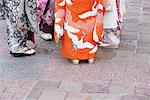 Frauen tragen Kimonos und Sandalen