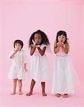 Studio Shot Of Children Blowing Feathers