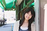 Japanische Teenager-Mädchen, an eine Wand gelehnt