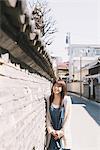 Girl Standing Against A Wall In Sunny Day