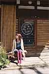 Japanese Girl Resting Outside On Wooden Bench