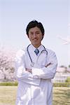 Arzt in Front von Kirschblüten