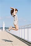 Young Woman Jumping By Seafront