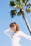 Young Woman Near A Palm Against Blue Sky