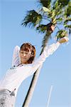 Jeune femme près d'un Palm Tree bras tendu