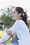 Pretty Young Woman Hugging Knees In Park