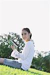 Pretty Young Woman In Park Reading Book