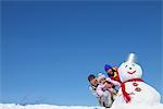 Parents With Their Daughter Near Snowman