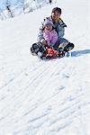 Father And Daughter sledging In Snow