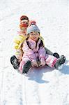Kleine Schwestern Schlittenfahren im Schnee