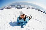 Kleines Mädchen Klettern im Schnee