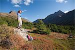 Woman hiker resting and enjoying the view in the Glen Alps area of Chugach State Park, Hidden Lake and the Ramp Trail, Chugach Mountains, Southcentral Alaska, Autumn