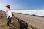 Portrait d'un chasseur Inupiaq Eskimo mâle portant son parka Eskimo (Atigi) et seal skin hat, tout en se tenant au lotissement urbain original de vieux Utkeagvik surplombant la mer des Tchouktches, Barrow, Alaska arctique, été