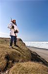 Portrait d'un chasseur Inupiaq Eskimo mâle portant son parka Eskimo (Atigi) et un chapeau de peau de phoque et tenant un bâton de marche à Utkeagvik ancien lotissement original avec vue sur la mer des Tchouktches, Barrow, Alaska arctique, l'été