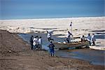 Whaling crew pushes their Umiaq off the Chuchki Sea ice at the end of the spring whaling season in Barrow, Arctic Alaska, Summer