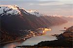 Aerial view of downtown Juneau and harbor at sunset with two cruise ships in port, Southeast Alaska, Summer