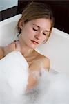 Femme se détendre dans le bain à bulles