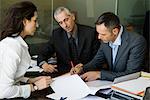 Executives signing paperwork in office