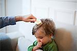 Father brushing toddler son's hair, cropped