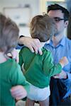 Father helping toddler son get dressed