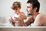 Father and toddler son taking a bath together