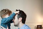 Kleinkind jungen spielen mit Vaters Haar
