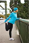 Woman Stretching on Bridge while Jogging, Seattle, Washington, USA