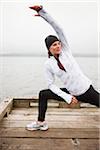 Frau Dehnung am Dock vor dem Joggen, Puget Sound, Seattle, Washington, USA