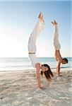Couple doing Handstands on Beach, Reef Playacar Resort and Spa, Playa del Carmen, Mexico