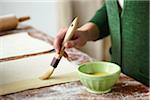 Woman Brushing Egg onto Pastry