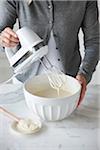 Woman Beating Cream Cheese Mixture with Electric Hand Mixer