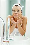 Woman washing her face in bathroom