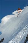 Skieur en tournant sur le visage de la montagne escarpée