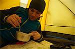 Man eating in camping tent